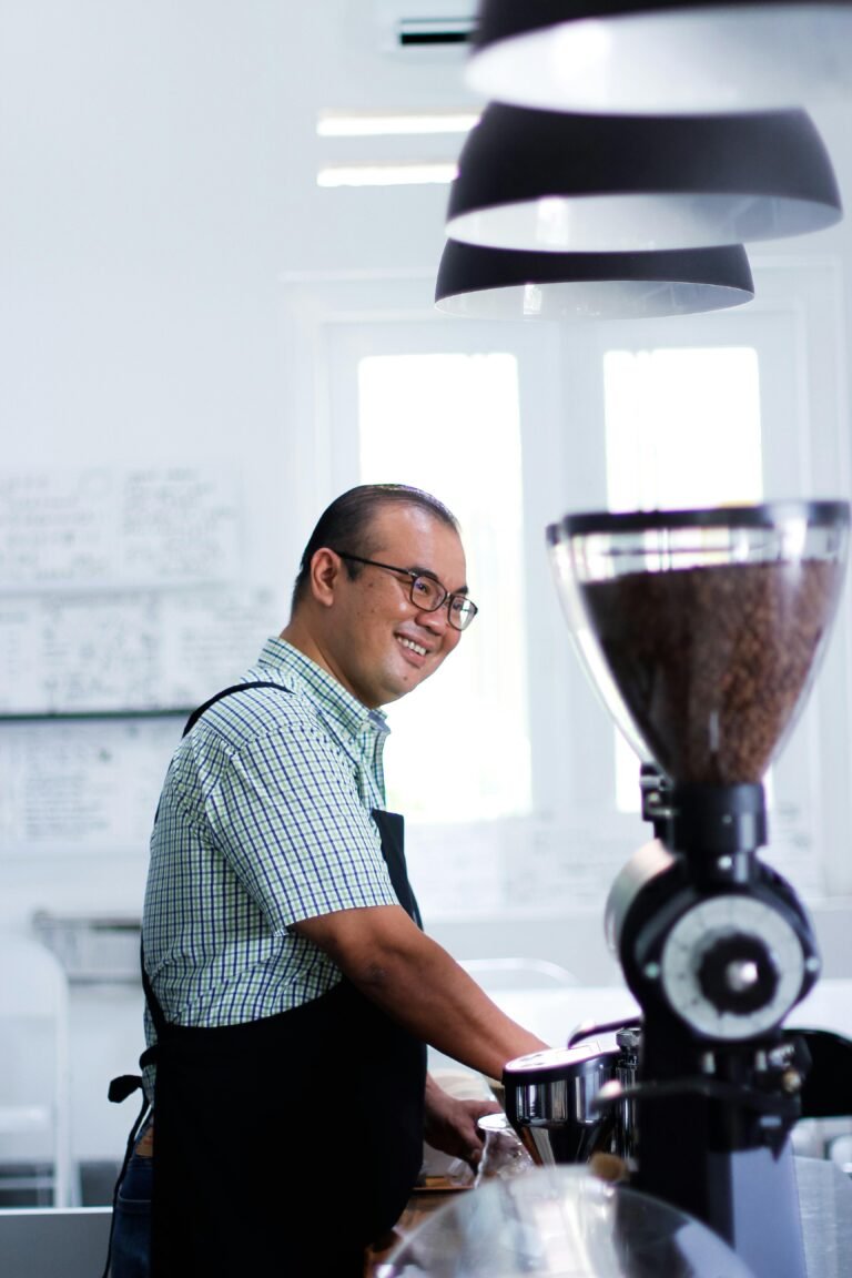 Barista grinding fresh coffee beans in a stylish modern café setting, creating a warm and inviting atmosphere.